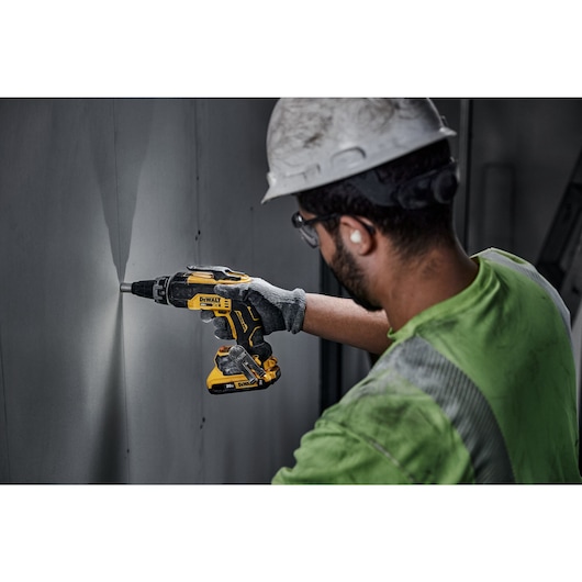 individual using a 20V MAX XR(®) Brushless Drywall Screwgun on a wall