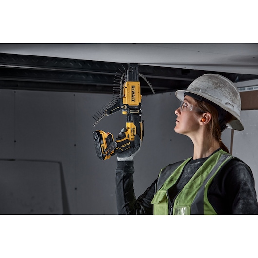 individual using a 20V MAX XR(®) Brushless Drywall Screwgun with collated attachment on ceiling