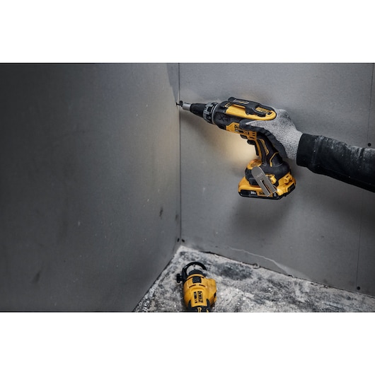 individual using a 20V MAX XR(®) Brushless Drywall Screwgun in a tight corner