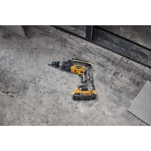 Drywall screwgun and cutout tool on floor in commercial setting