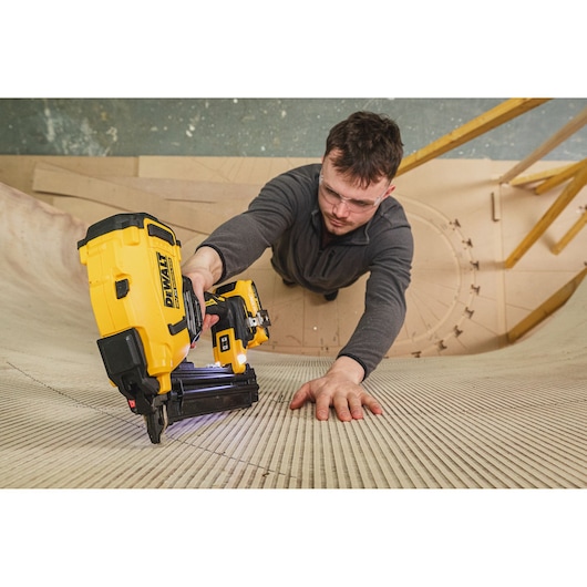 DEWALT BSV520BRB and DCN210SN-XJ used in construction, person’s face blurred, photography category.