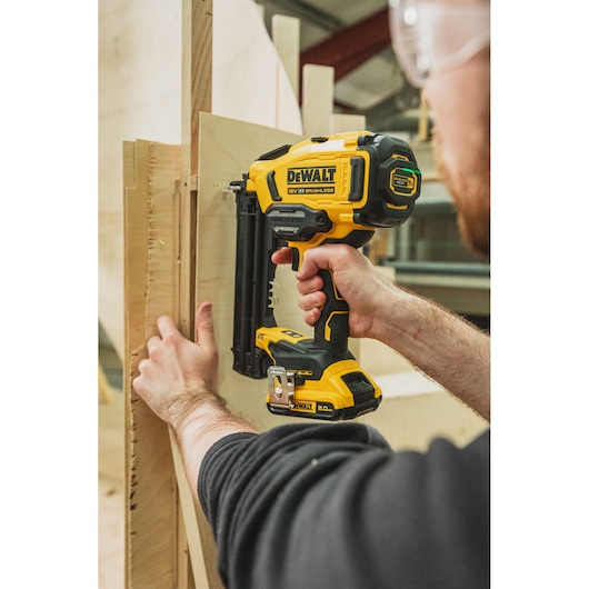 DEWALT tools BSV520BRB, DCN210SN-XJ used for woodworking. Person operates yellow cordless nailer.