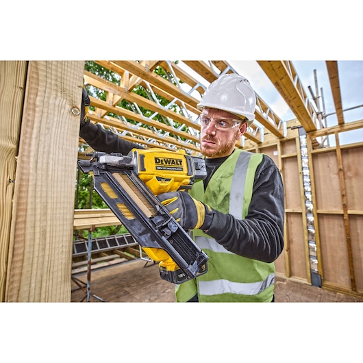 18V XR Brushless framing nailer being used to drive nails into a wooden frame