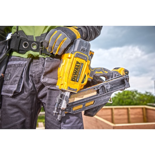 	Close view of a DCN930 18V XR Brushless framing nailer suspended from a worker's toolbelt