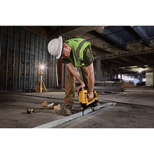 Trak-It C6 Gas Concrete Nailer being used by a person to install drywall track into floor.